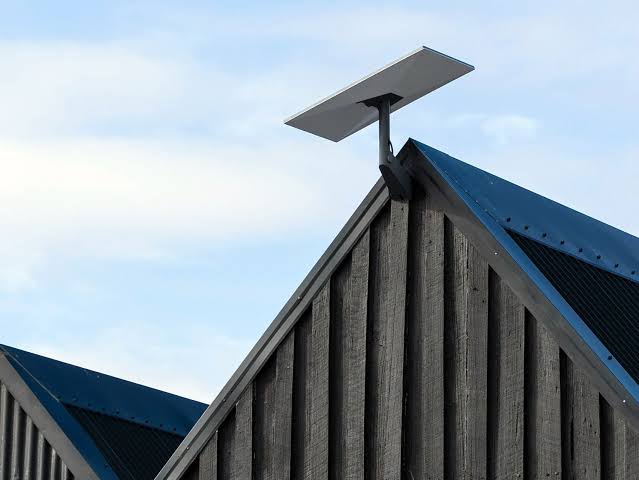 Antenne Starlink installée sur un toit sous un ciel bleu dégagé